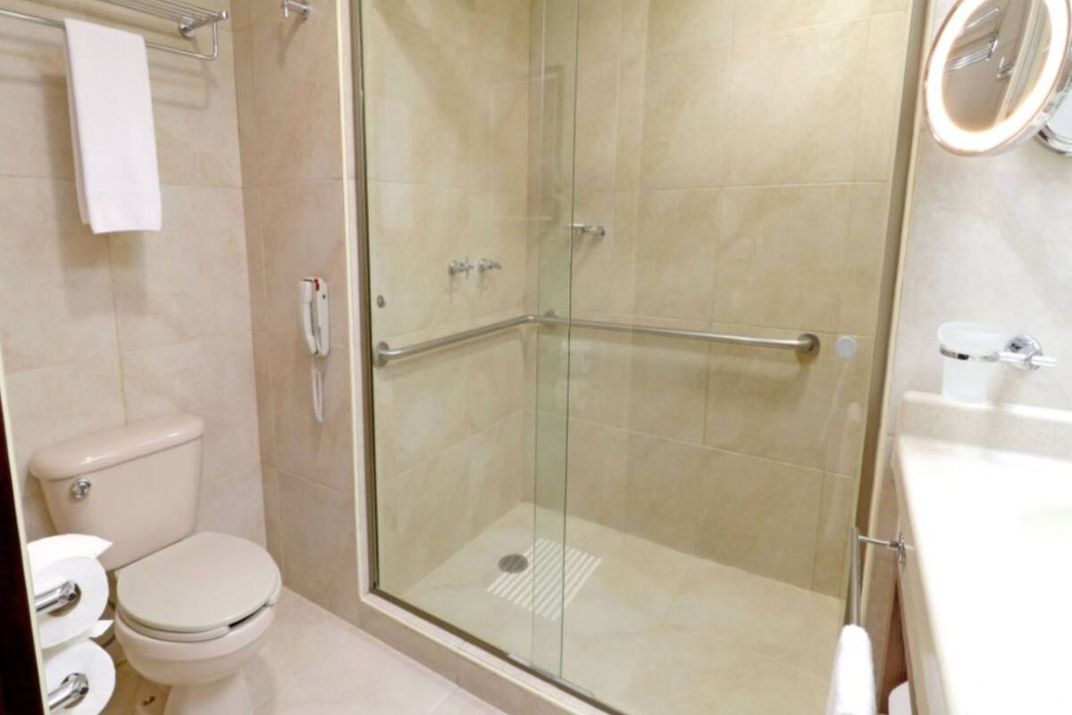 Une salle de bain moderne avec une douche à parois de verre, des toilettes et un lavabo avec un miroir.