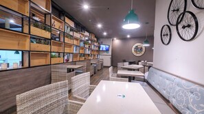 A restaurant interior with wicker furniture, wooden shelves, and a wall clock. - Holiday Inn Hotel & Suites Medica Sur by IHG (Mexico City)