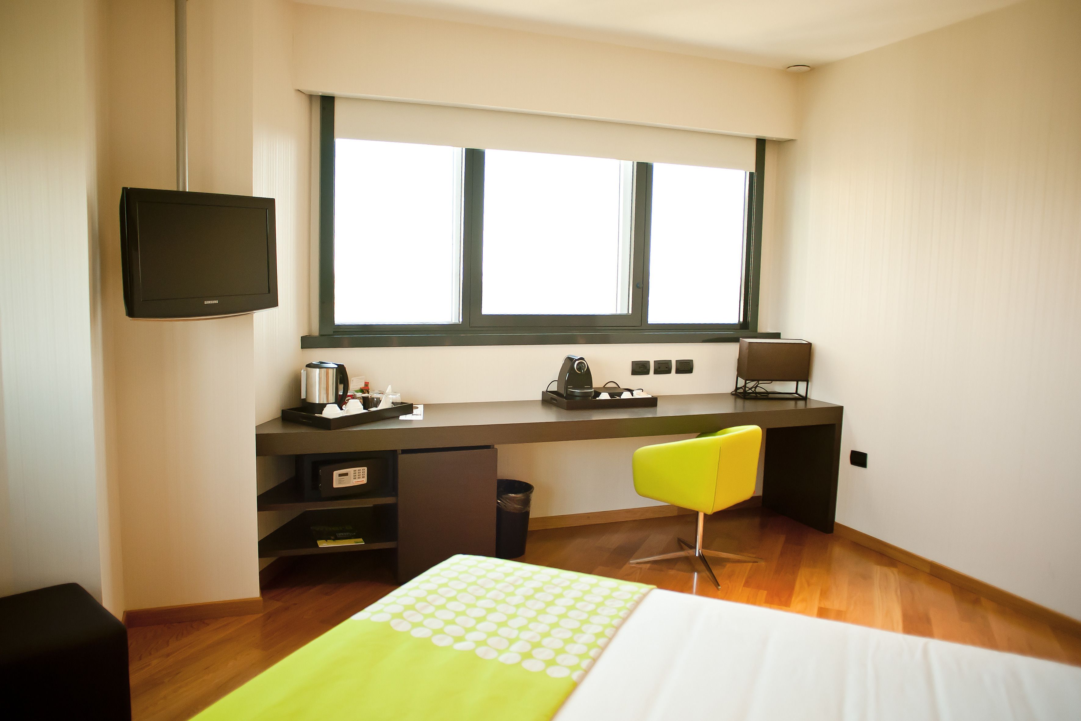 Una habitación de hotel moderna con escritorio, silla y cama.