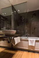 Un bagno moderno con uno specchio grande, un lavabo a incasso, una vasca e una doccia.