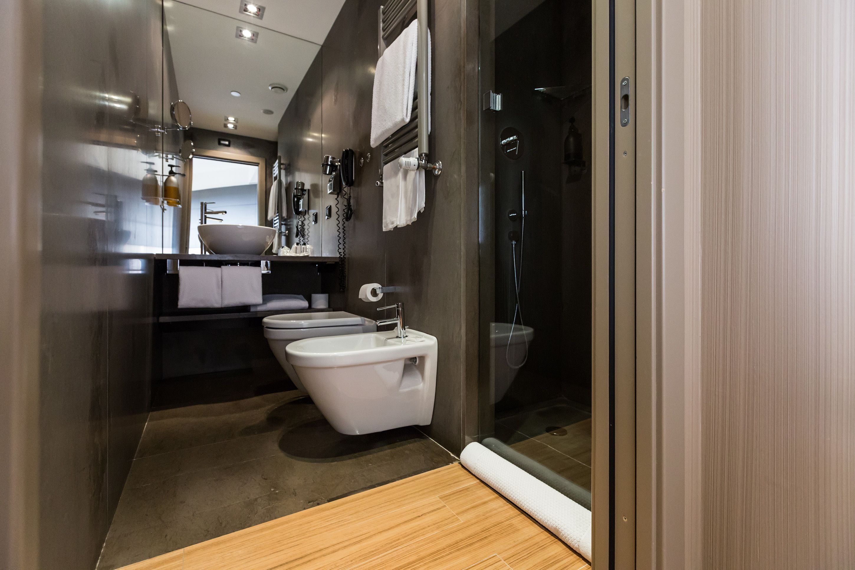 A modern bathroom with a bidet, toilet, and shower.