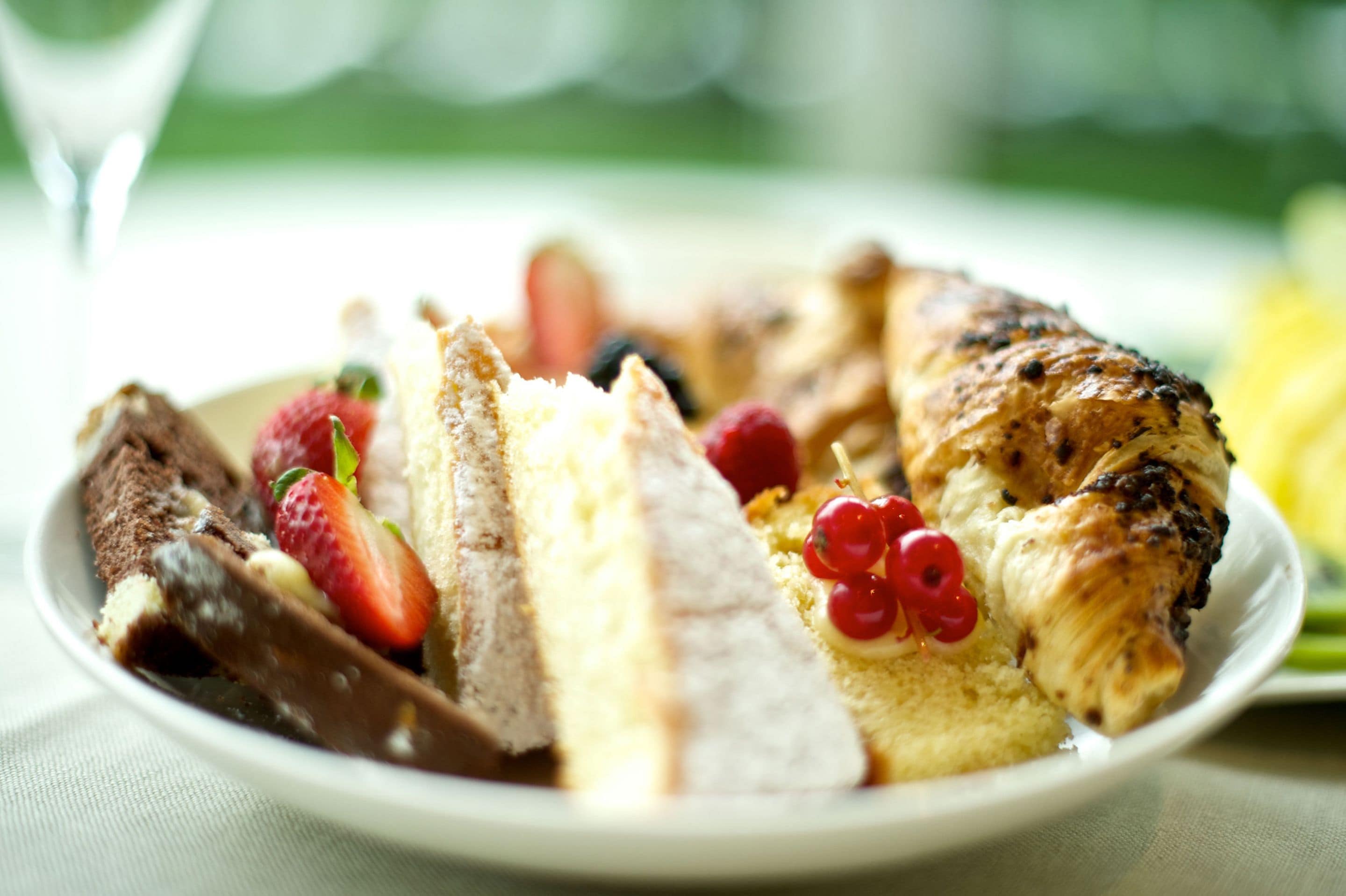 Ein Teller mit Speisen, darunter ein Kuchenstück, Erdbeeren und Beeren.