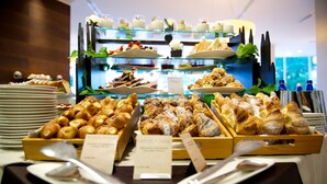 Un buffet proposant une variété de viennoiseries et de desserts, notamment des croissants et des gâteaux, présentés sur plusieurs étagères.
