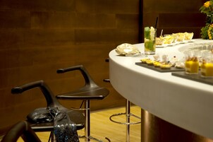 A round table with a white tablecloth, a glass of iced tea, and a tray of appetizers.
