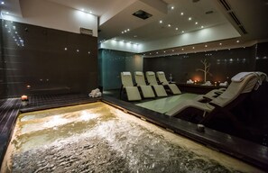 A spa room with a hot tub, multiple lounge chairs, and candles. - Best Western Plus The Hub Hotel (Milan)