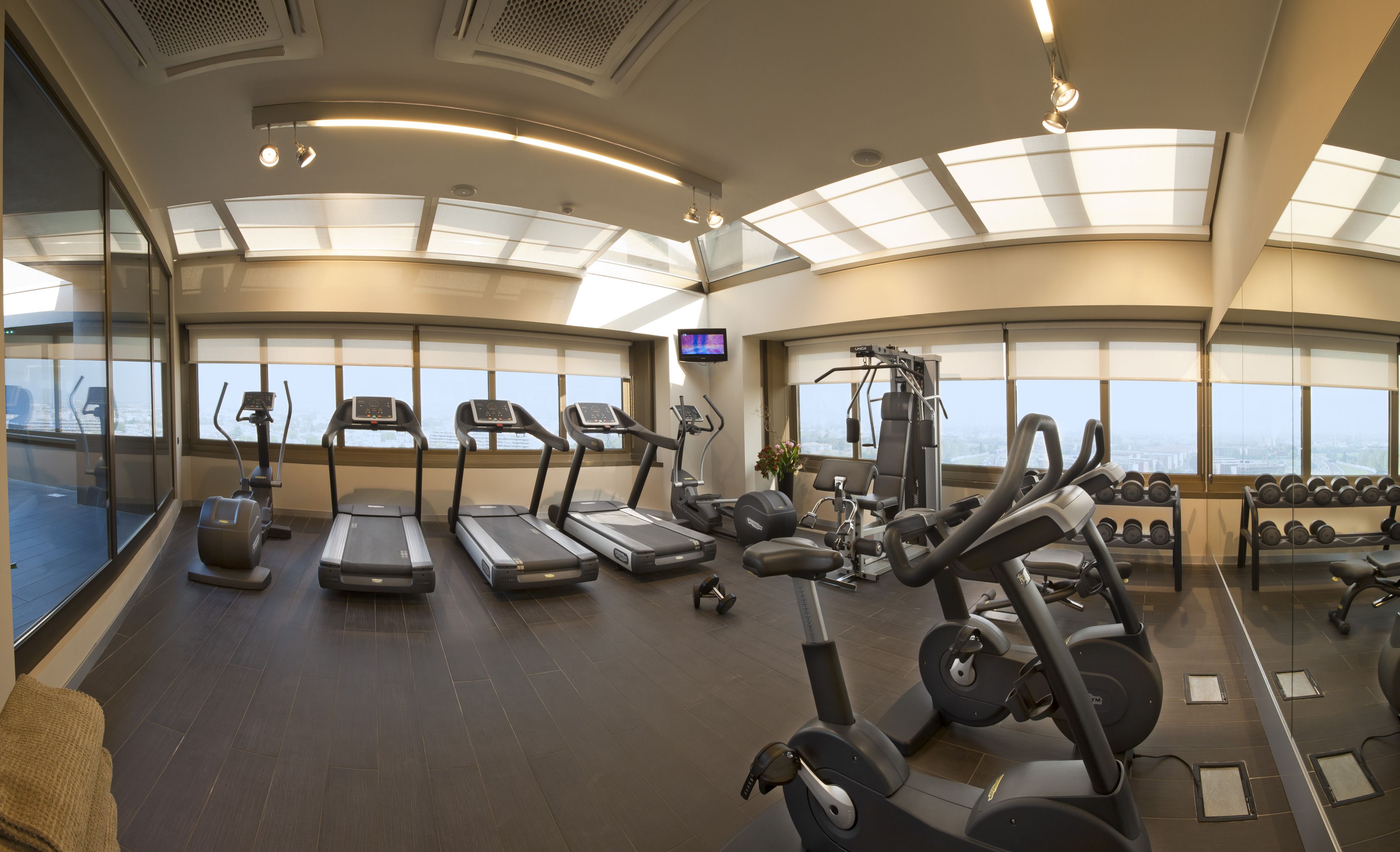 A gym with treadmills, elliptical machines, and free weights.