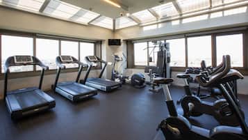 Uma academia com esteiras, elípticos e equipamentos de musculação.