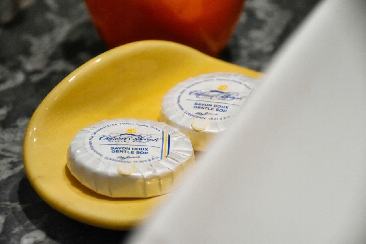 Dos pastillas de jabón en un plato amarillo.