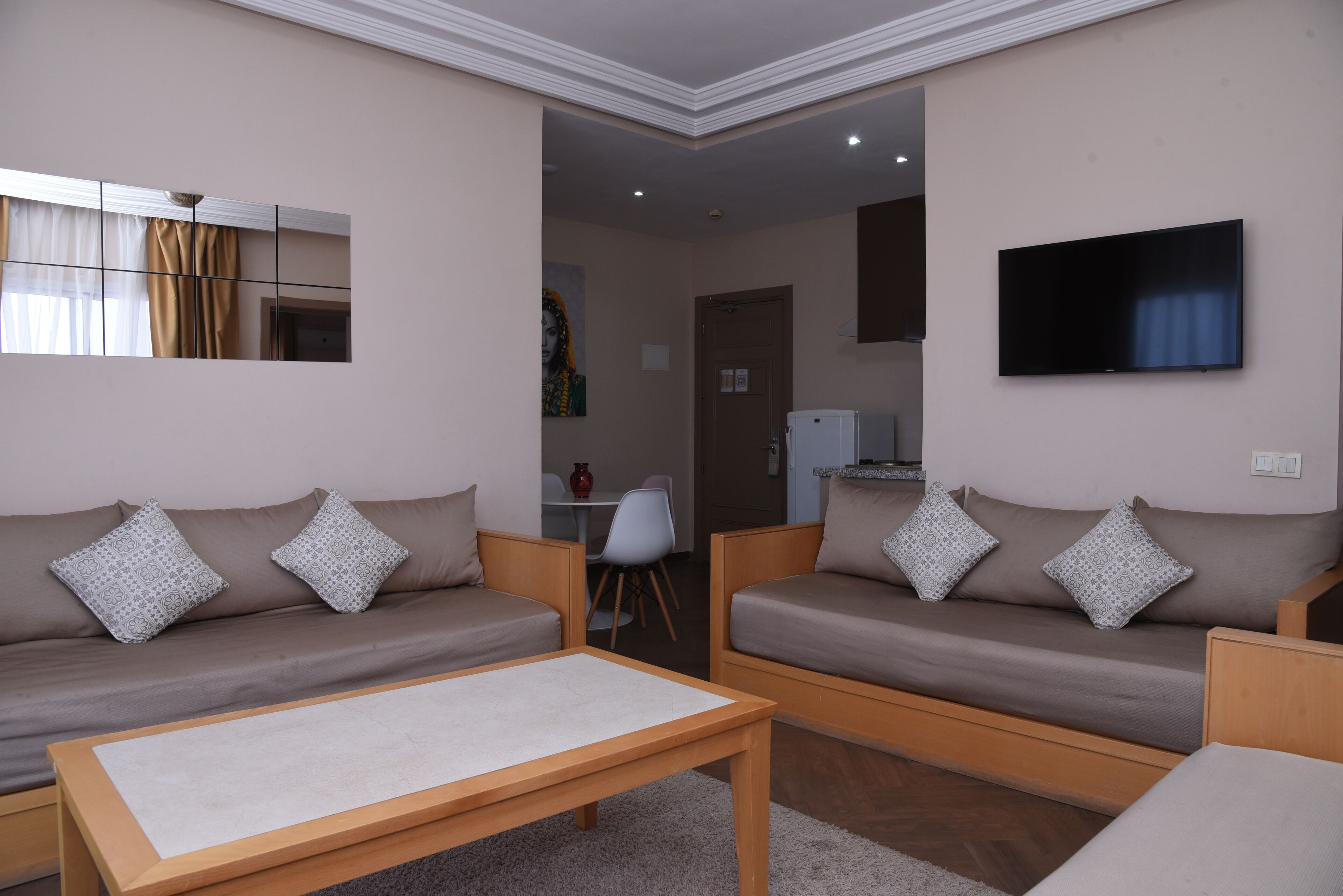 A modern living room with two sofas, a coffee table, and a flat-screen TV.