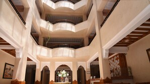 A multi-level atrium with a central staircase, seating areas, and a reception desk. - Golden Beach Appart'hotel (Agadir)