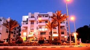 A multi-story hotel with a modern facade, balconies, and a well-lit entrance. - Golden Beach Appart'hotel (Agadir)