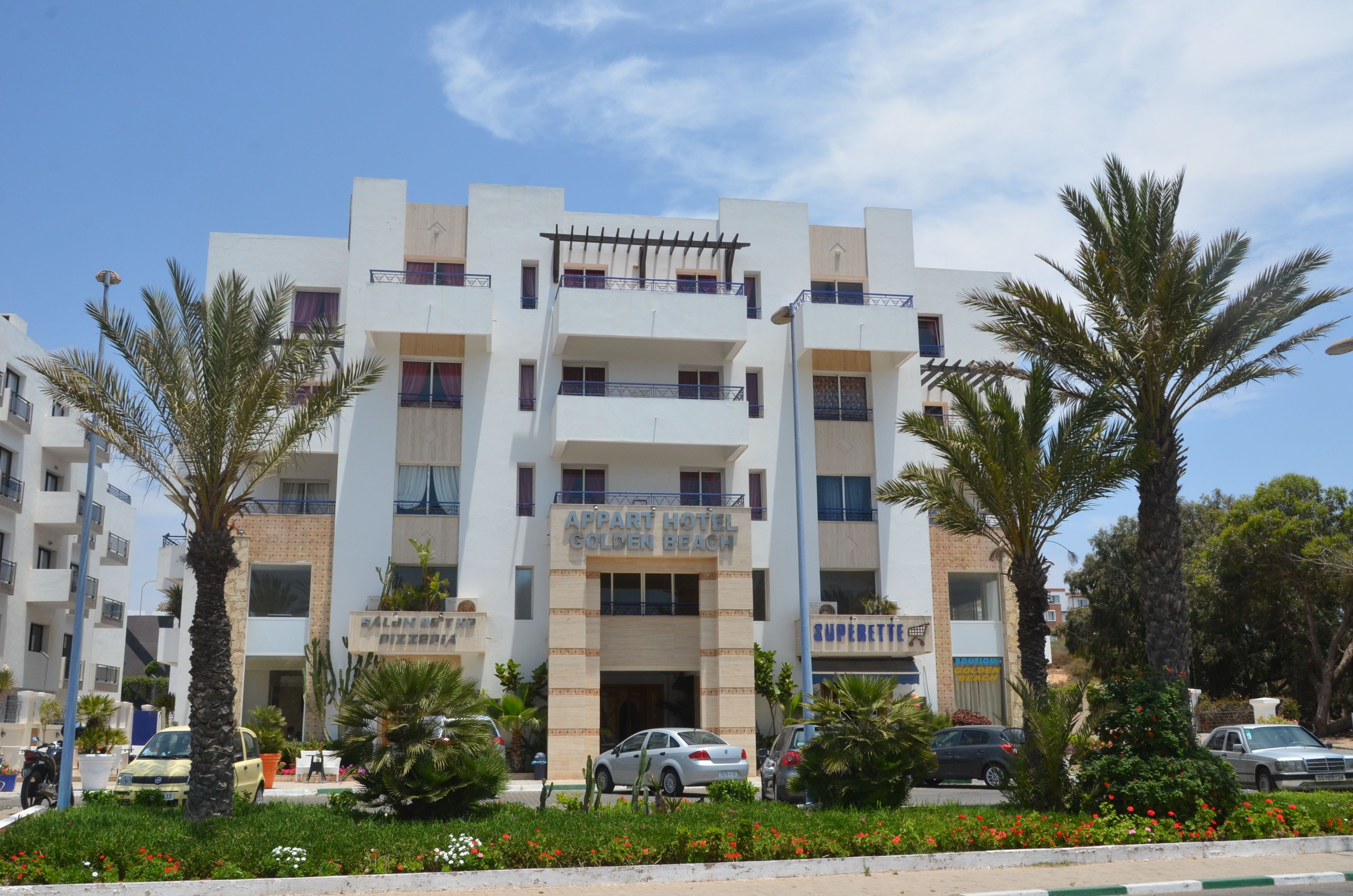 Un edificio de varios pisos con un letrero que dice 'APART HOTEL GOLDEN BEACH'.