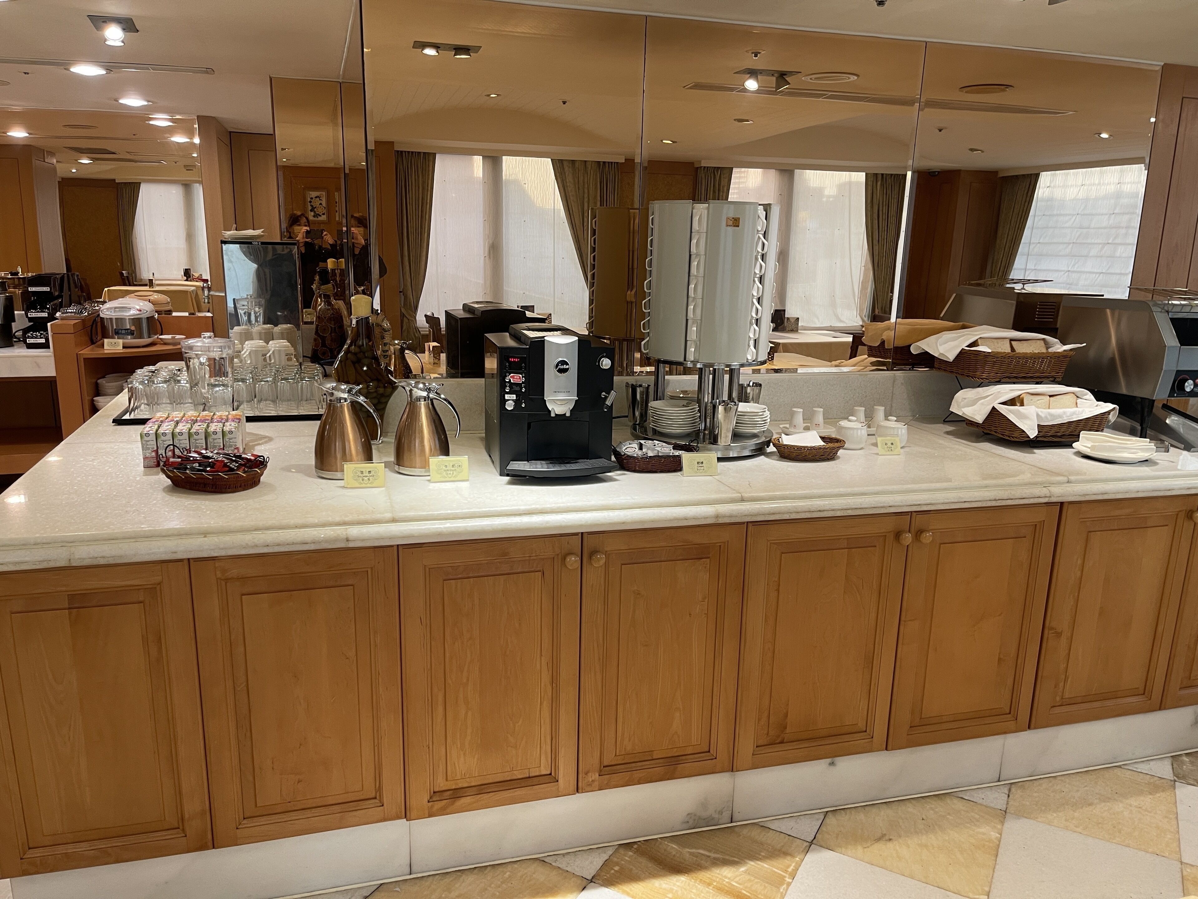 Ein Hotel-Frühstücksbereich mit einer Kaffeemaschine, Teekannen und einem Buffet.
