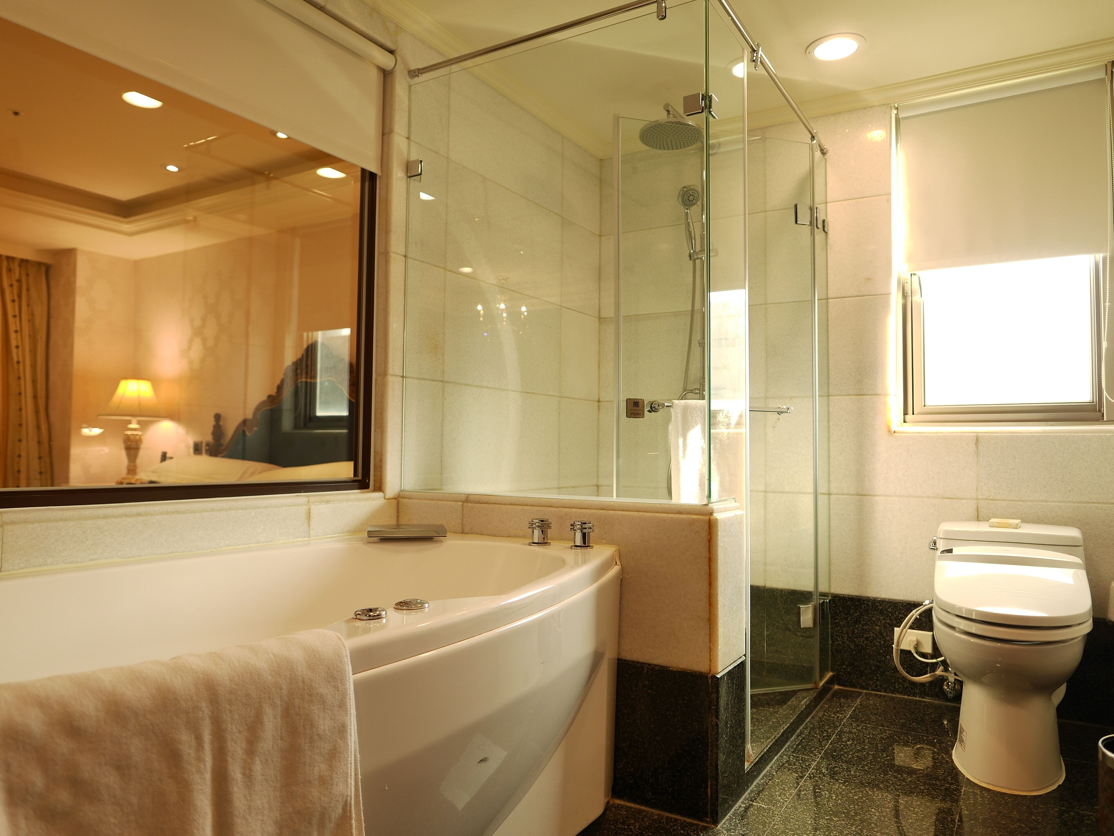 Une salle de bain moderne avec une douche à parois de verre, une baignoire sur pieds et des toilettes.