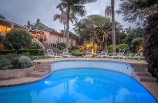 室外游泳池，池畔遮阳伞，日光浴躺椅