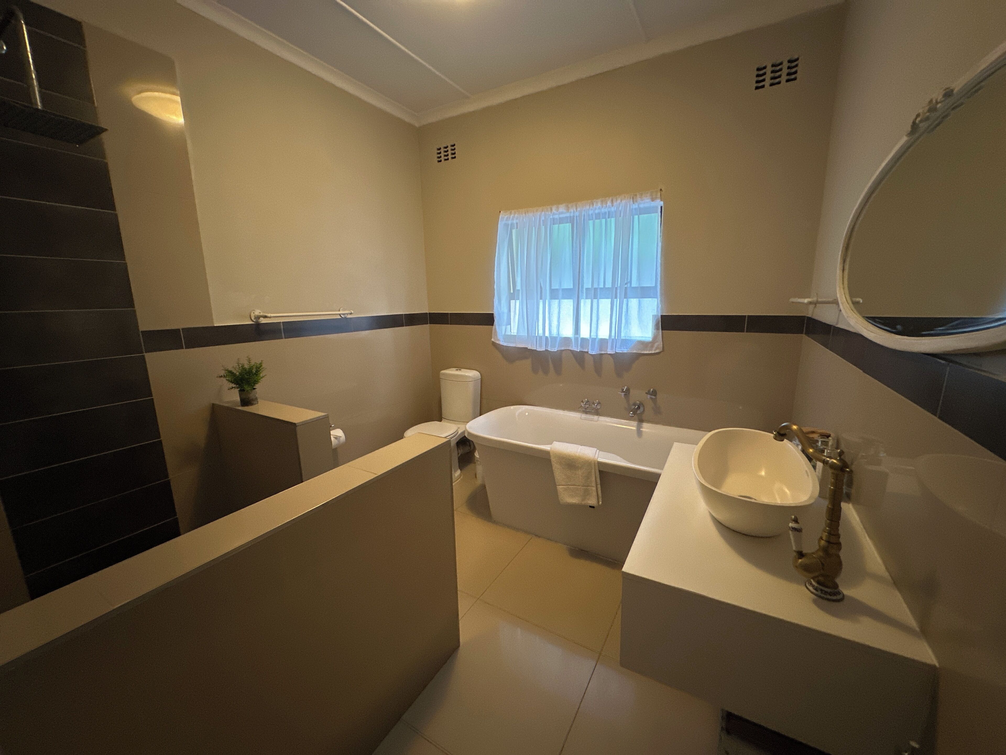 Un baño moderno con bañera, lavamanos e inodoro.