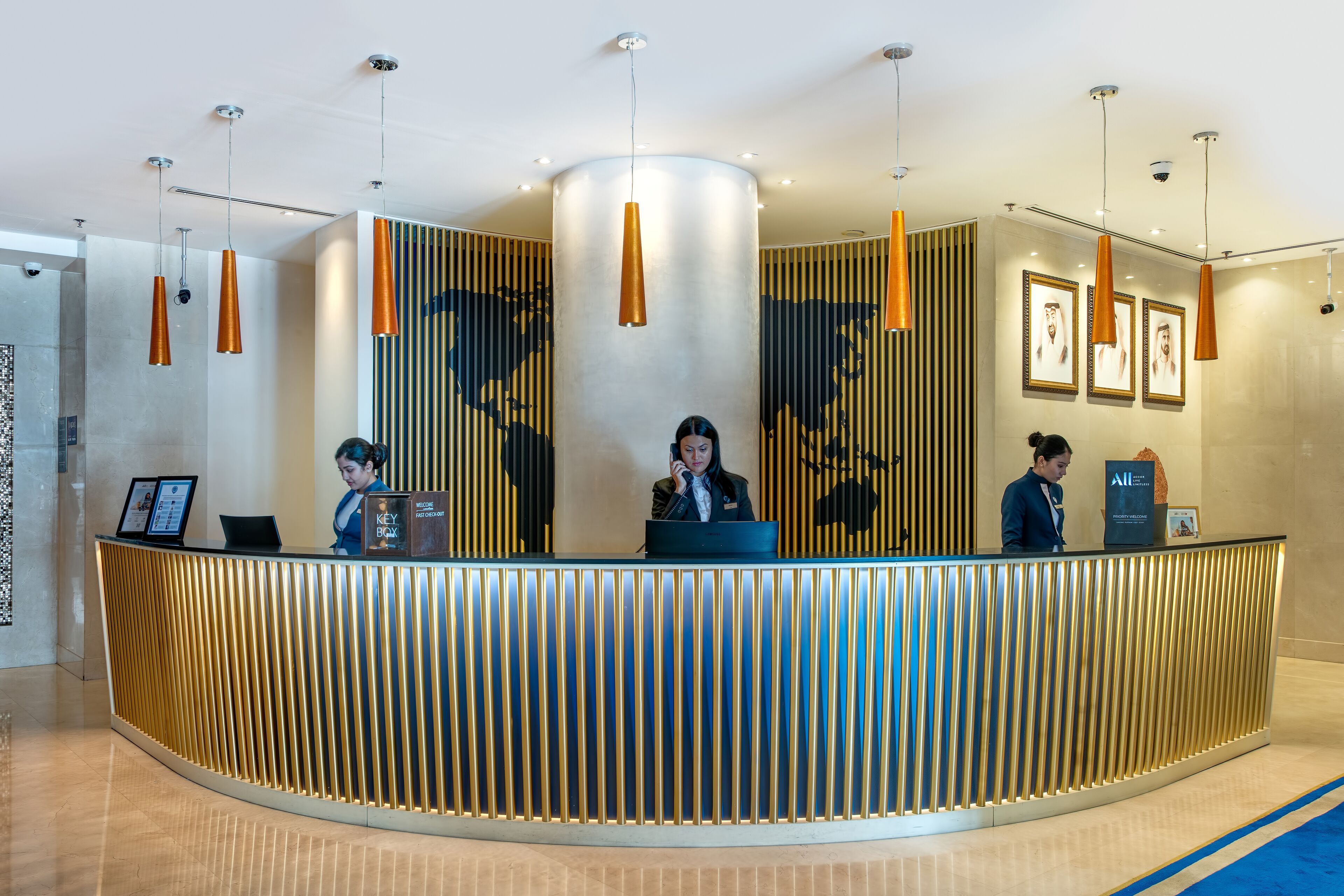 Un comptoir d’accueil au design moderne, caractérisé par une forme incurvée et un revêtement mural vertical.