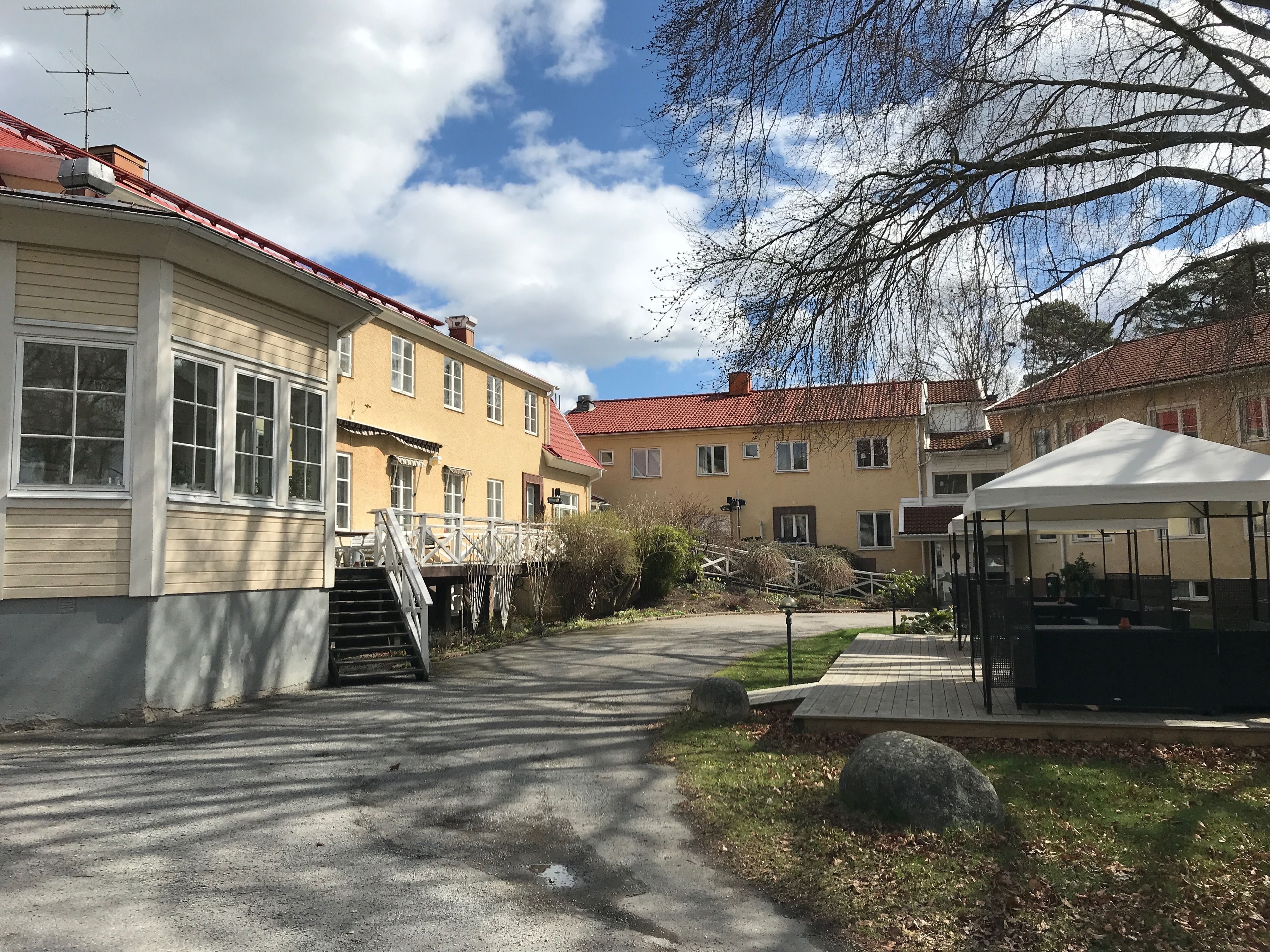 A residential street with houses, a covered walkway, and a gazebo.
