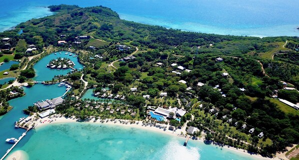 An aerial view of a resort with multiple buildings, a beach, and a marina.