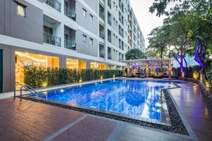 Una piscina al aire libre, sillones reclinables de piscina