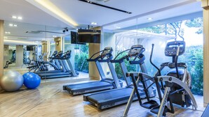 Un gimnasio moderno con cintas de correr, elípticas y pelotas de ejercicio.