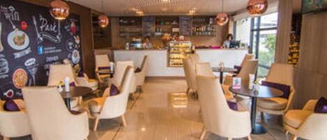 A modern cafe with a bar area, seating arrangements, and a menu wall.