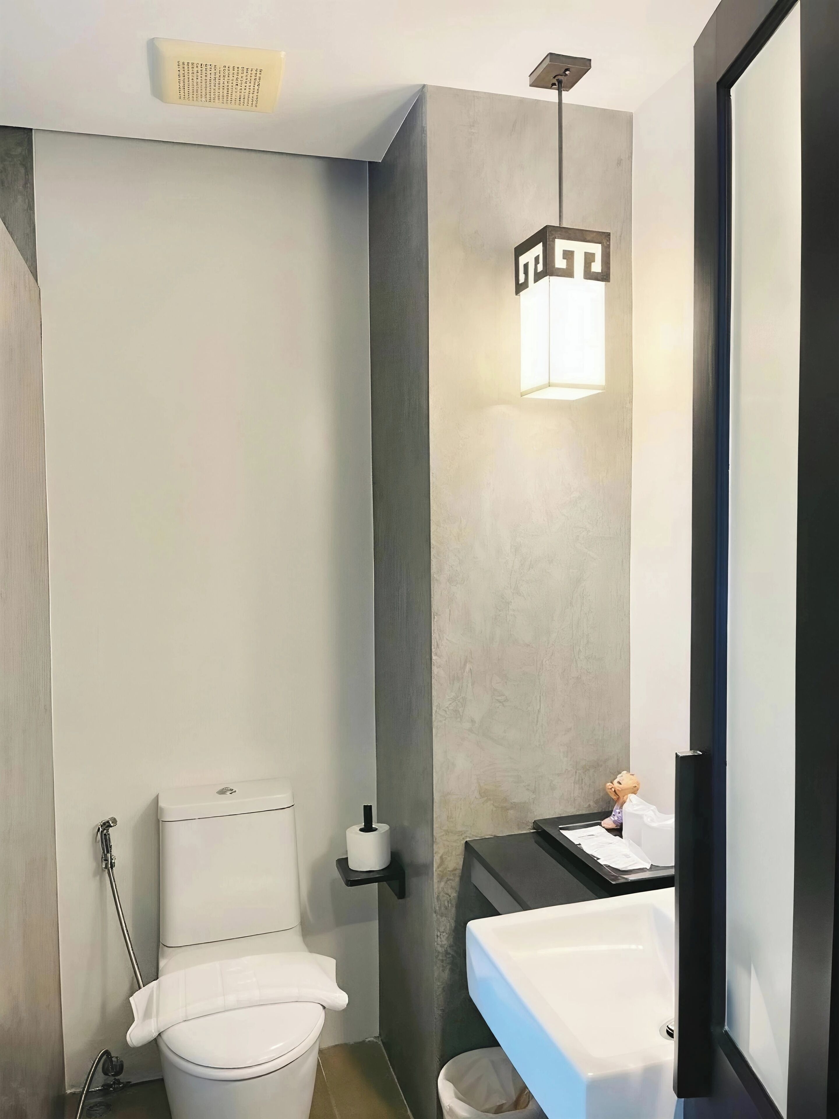 A modern bathroom with a toilet, sink, and a towel rack.