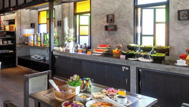 A breakfast buffet setup with various food items and condiments. - Phuketa Hotel Phuket Town (Ratsada)