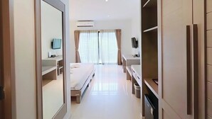 A hotel room with a bed, a desk, a TV, and a wardrobe. - Phuketa Hotel Phuket Town (Ratsada)