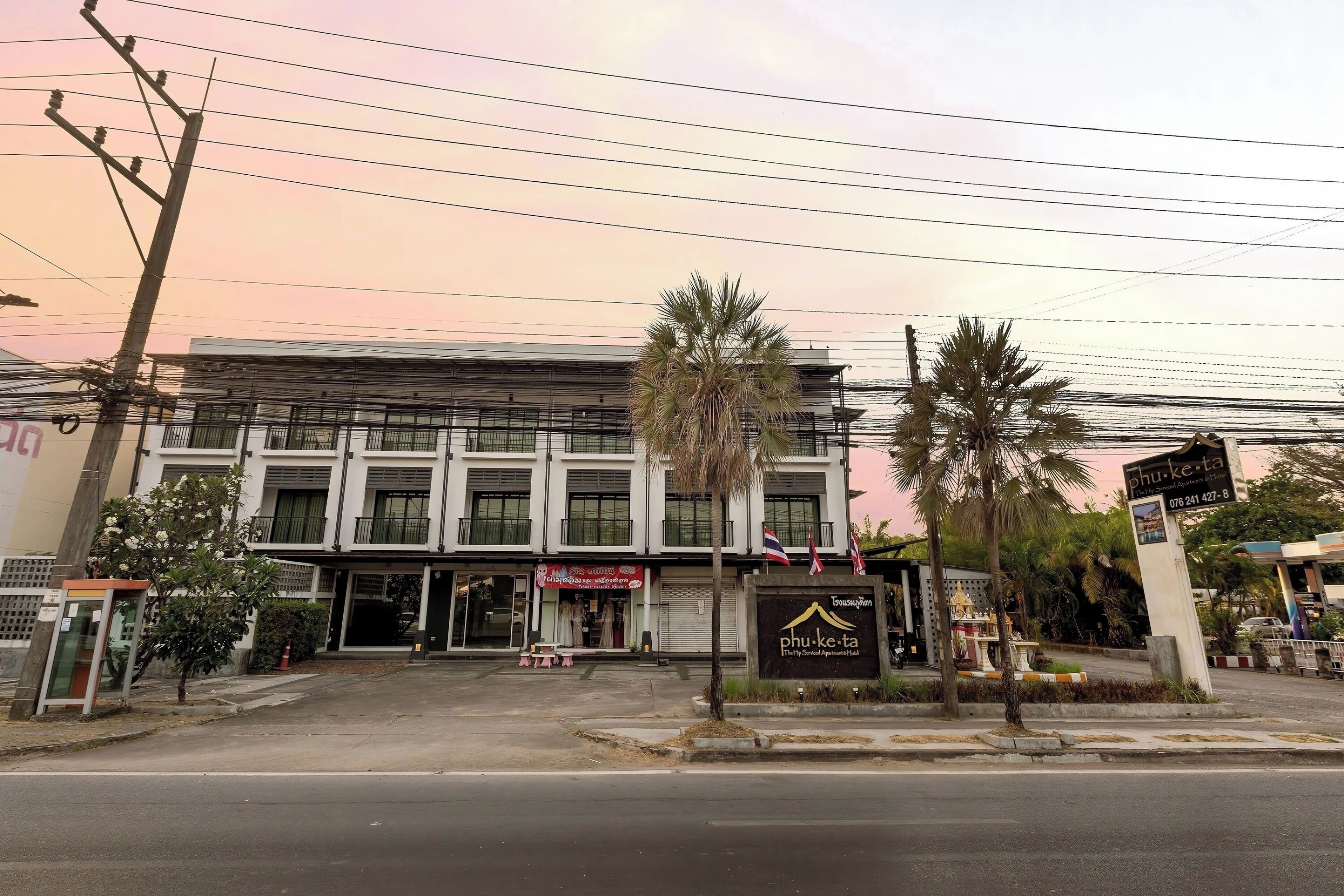 Un edificio con un letrero que dice 'Phu-ke-ta' y una fachada visible con un letrero que indica 'Café'.