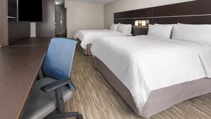 A hotel room with a large bed, a desk with a chair, a flat-screen TV, and a separate seating area with a chair. - Holiday Inn Express Hotel & Suites Hamburg by IHG (Hamburg)