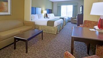A hotel room with a bed, a sofa, a desk, and a chair.