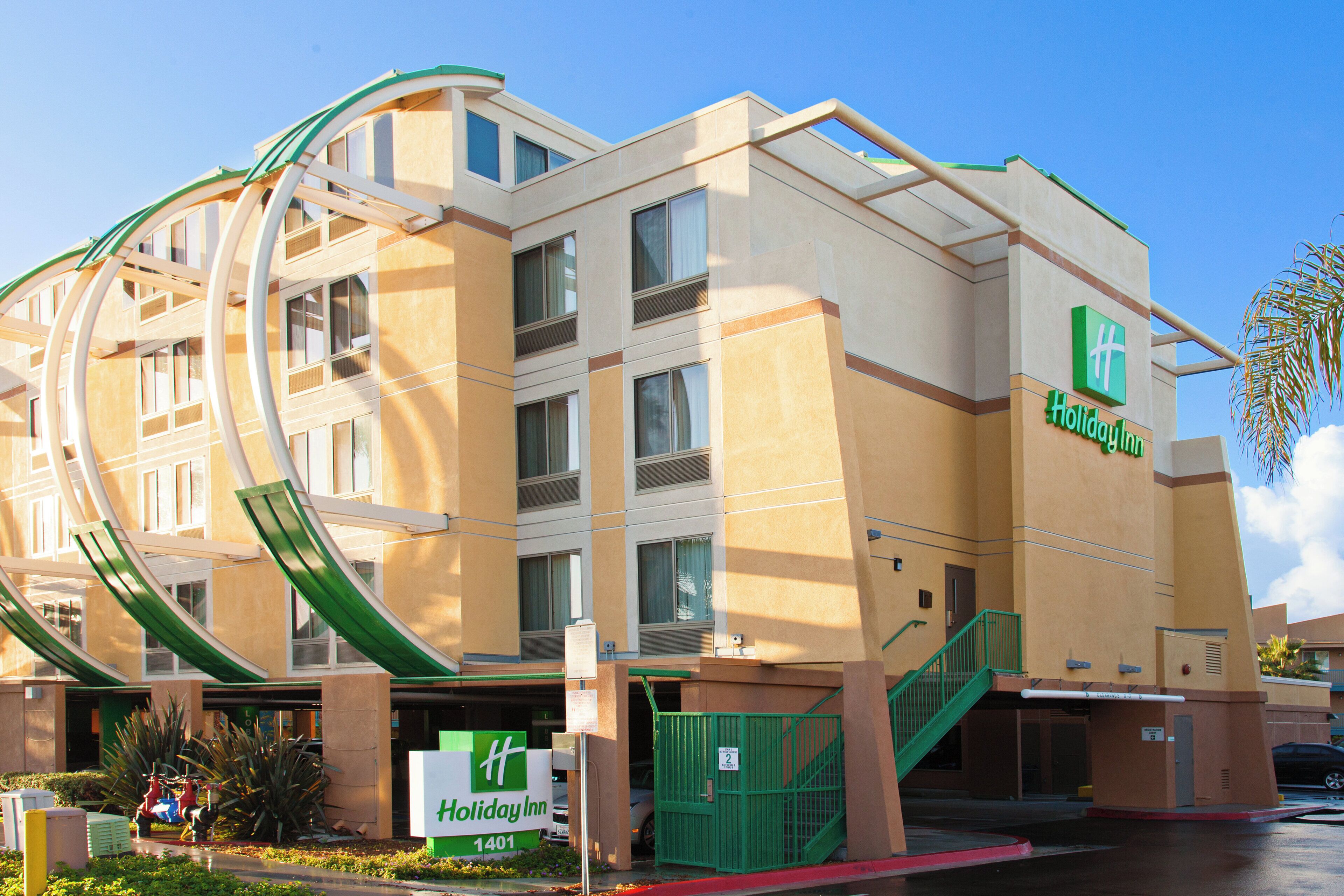 Um hotel Holiday Inn com uma entrada curva característica e um letreiro verde.