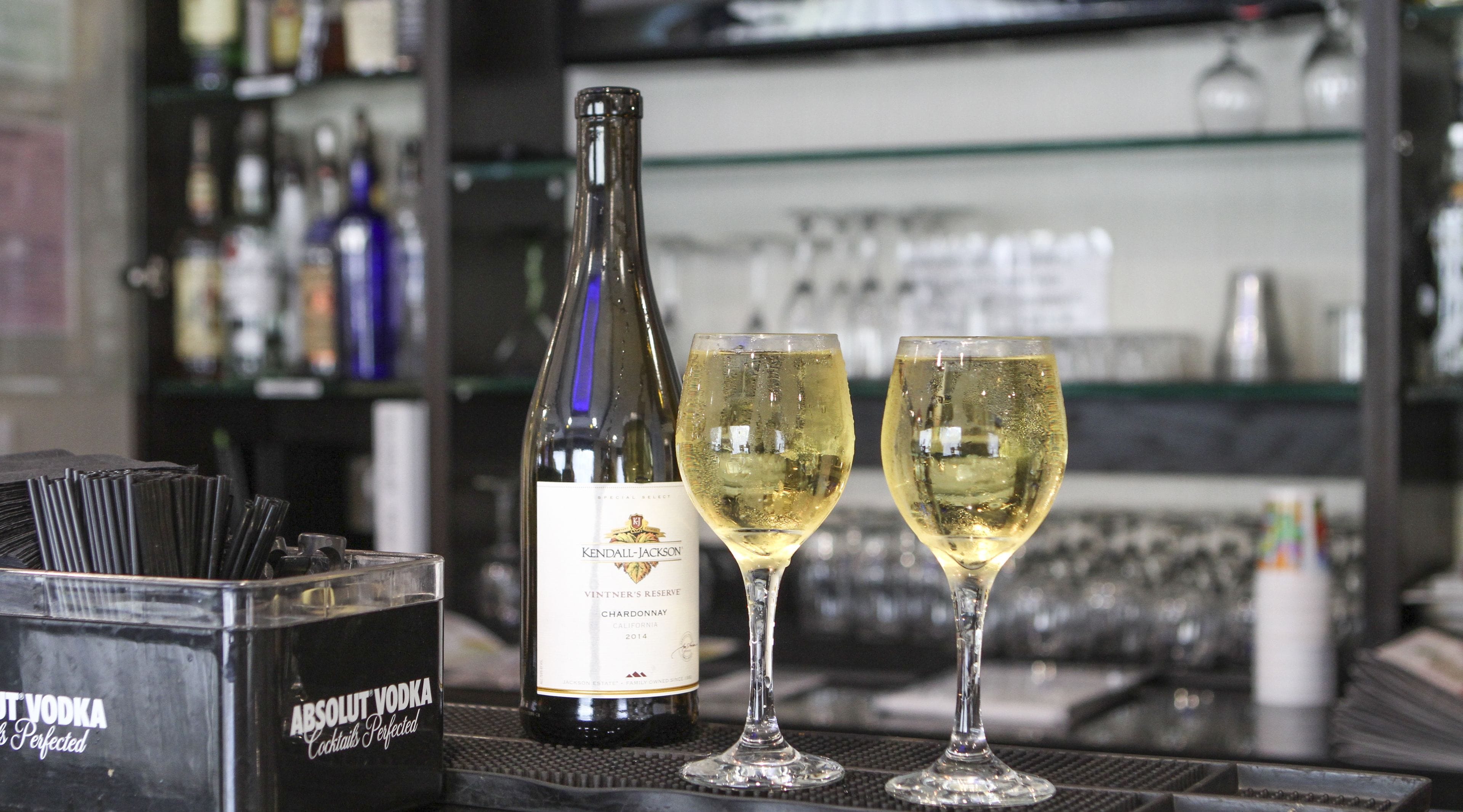 Een bar, met een fles Kendall-Jackson Chardonnay en twee wijnglazen.