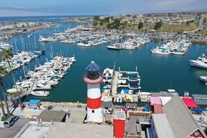 A marina with multiple boats docked, a prominent lighthouse, and a view of the surrounding town. - Holiday Inn Oceanside Camp Pendleton Area by IHG (Oceanside)