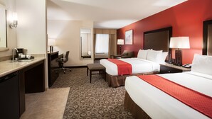 A hotel room with two beds, a desk, a chair, a small table, and a bathroom. - Holiday Inn Oceanside Camp Pendleton Area by IHG (Oceanside)