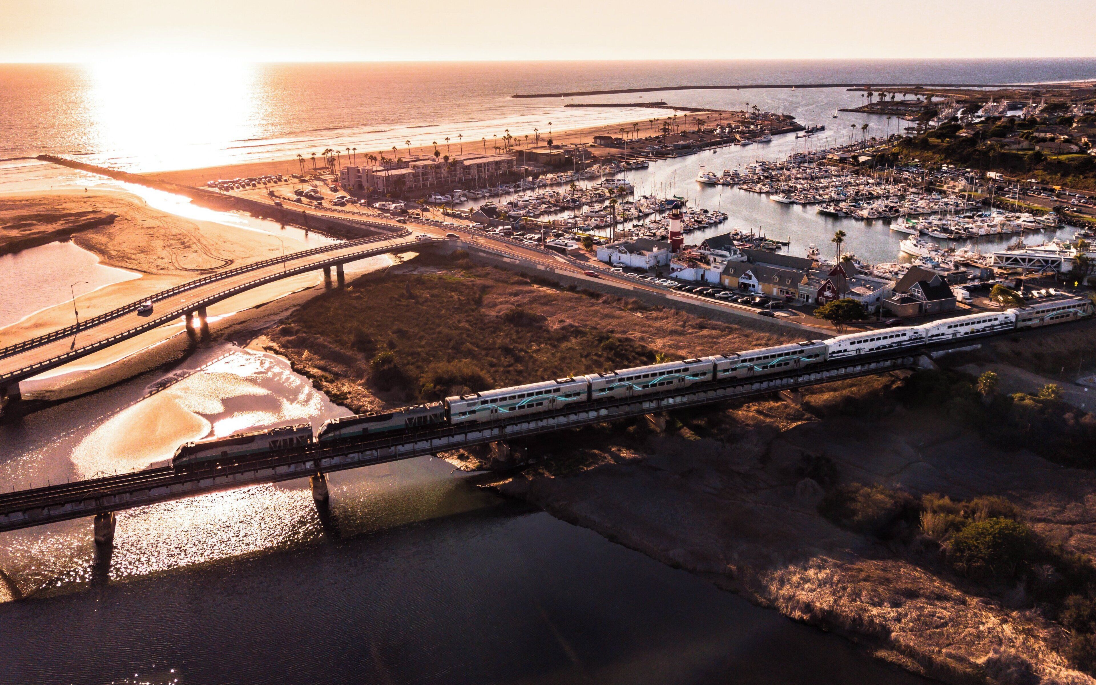 A coastal town with a bridge, marina, and a train crossing.