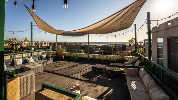 A rooftop terrace with outdoor seating, string lights, and a view of the cityscape. - Holiday Inn Oceanside Camp Pendleton Area by IHG (Oceanside)