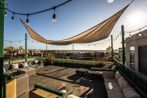 A rooftop terrace with outdoor seating, string lights, and a view of the cityscape. - Holiday Inn Oceanside Camp Pendleton Area by IHG (Oceanside)