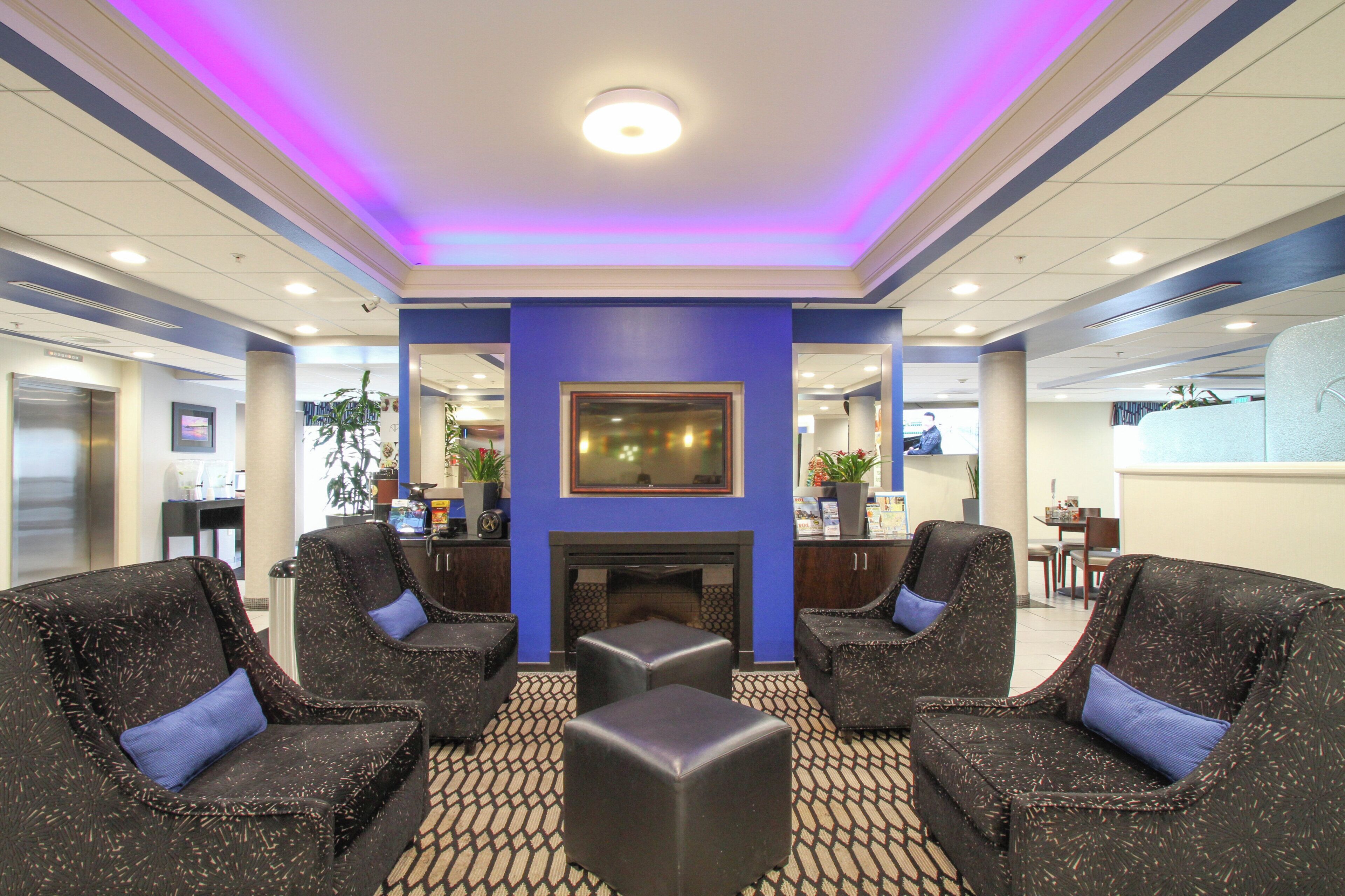 A lobby with a fireplace, seating area, and a reception desk.