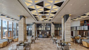 A spacious lobby with a central bar, large seating areas, and a modern ceiling design. - Radisson Blu Hotel & Convention Center, Alexandria (Al-'Amriyah)