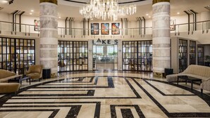 A spacious lobby with a central geometric floor design, large marble columns, and a prominent chandelier. - Radisson Blu Hotel & Convention Center, Alexandria (Al-'Amriyah)