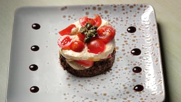 Un plato cuadrado con un postre sobre una mesa.