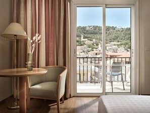 A hotel room with a balcony, a table with a lamp, a chair, and a bed. - Hotel Strada Marina (Zakynthos)