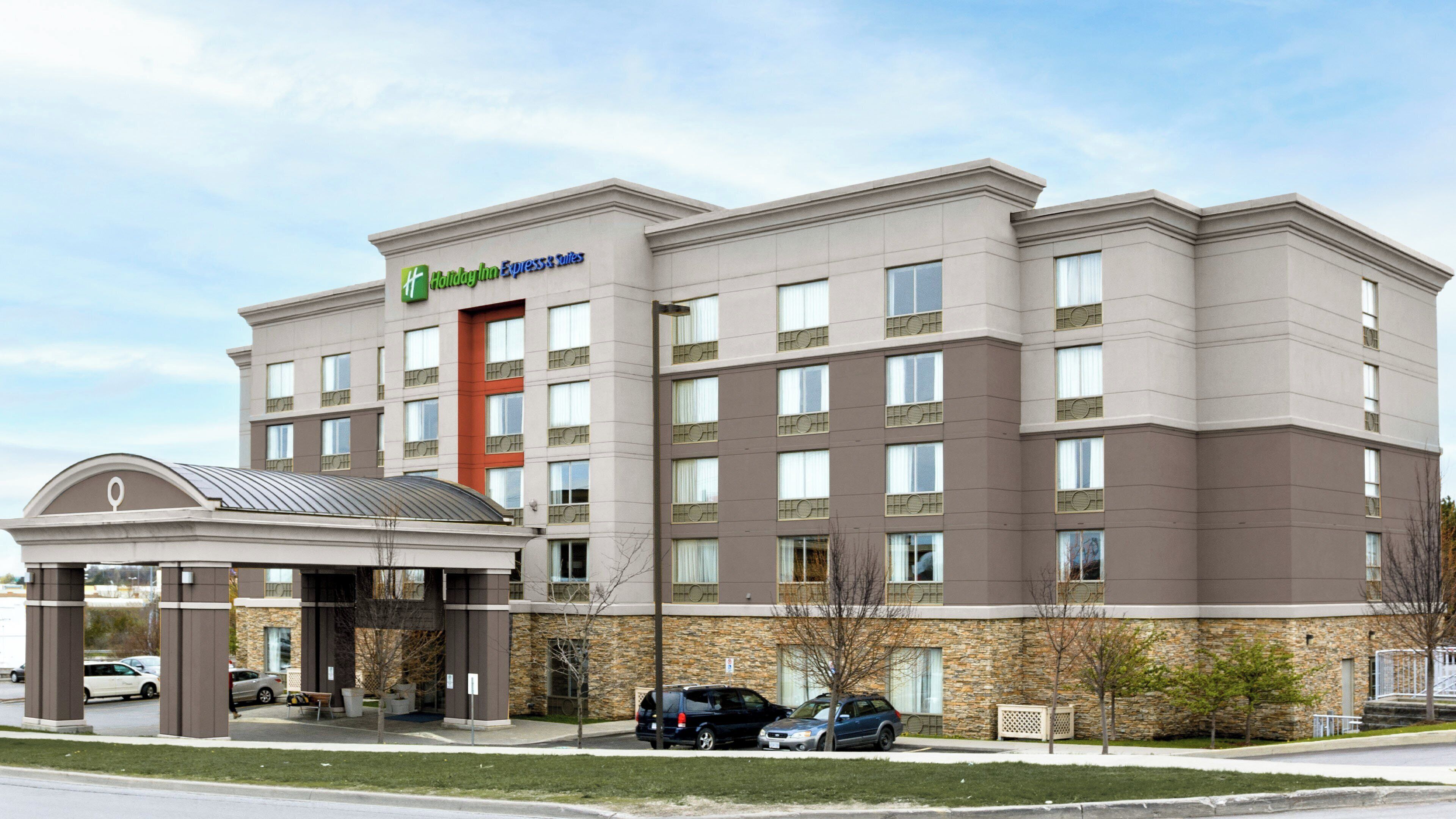 A Holiday Inn Express building with a stone facade, multiple windows, and a covered entrance.