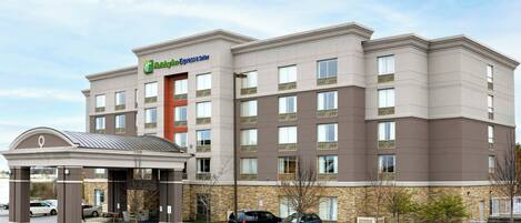 A Holiday Inn Express building with a stone facade, multiple windows, and a covered entrance.