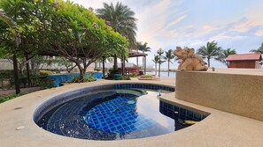 A swimming pool with a unique blue mosaic design, surrounded by palm trees and a statue of an elephant. - Serene Sands Health Resort (Bang Lamung)