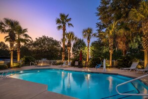Una piscina al aire libre, sillones reclinables de piscina