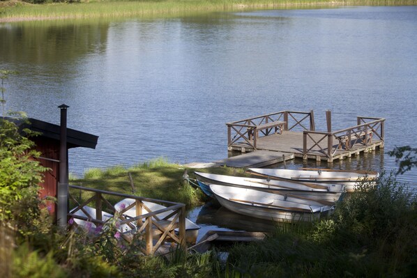 A dock with boats and a small building by the water.