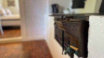 A close-up of a kitchen corner with a wooden countertop, a metal appliance, and a green faucet.